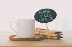 sinal com texto: GRANDE IDEAL, AJUSTOU OBJETIVOS, TOMA A AÇÃO ao lado da xícara de café sobre a tabela de madeira imagens de stock sinal com texto: GRANDE IDEAL, AJUSTOU OBJETIVOS, TOMA A AÇÃO ao lado da xícara de café sobre a tabela de madeira imagens de stock