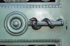 Sinete da serpente na porta do metal imagens de stock Sinete da serpente na porta do metal imagens de stock