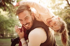 Father and daughter in park. Single father carrying her daughter on shoulders. Little girl looking at camera royalty free stock photo Father and daughter in park. Single father carrying her daughter on shoulders. Little girl looking at camera royalty free stock photo