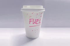 Single-use coffee cup with the word fuel written on it in purple text royalty free stock images Single-use coffee cup with the word fuel written on it in purple text royalty free stock images