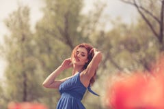 Sinnliche Frau auf dem roten Blumengebiet am sonnigen Tag Lizenzfreies Stockfoto Sinnliche Frau auf dem roten Blumengebiet am sonnigen Tag Lizenzfreies Stockfoto