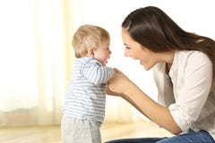 Sira de mãe a ajudar seu filho do bebê em suas primeiras etapas imagens de stock royalty free Sira de mãe a ajudar seu filho do bebê em suas primeiras etapas imagens de stock royalty free