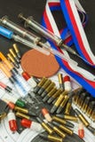 Siringa e medaglie Verniciando nello sport della fucilazione Abuso degli steroidi anabolizzanti per gli sport Inganno nel biathlo immagini stock Siringa e medaglie Verniciando nello sport della fucilazione Abuso degli steroidi anabolizzanti per gli sport Inganno nel biathlo immagini stock