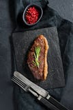 Sirloin beef steak with rosemary. Black background, top view. royalty free stock photography Sirloin beef steak with rosemary. Black background, top view. royalty free stock photography