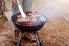 Sirva cocinar, sólo las manos, él están asando a la parrilla la carne o el filete para un plato Carne asada a la parrilla delicio imagenes de archivo Sirva cocinar, sólo las manos, él están asando a la parrilla la carne o el filete para un plato Carne asada a la parrilla delicio imagenes de archivo