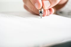 Sirva la escritura en un documento con una pluma imagen de archivo Sirva la escritura en un documento con una pluma imagen de archivo