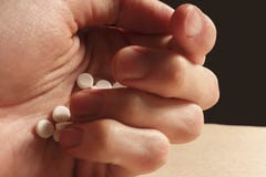 Sirva los controles de la mano del ` s una pila de píldoras blancas fotografía de archivo Sirva los controles de la mano del ` s una pila de píldoras blancas fotografía de archivo