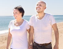 Sirva y una mujer de mediana edad que se sienta en la playa foto de archivo libre de regalías Sirva y una mujer de mediana edad que se sienta en la playa foto de archivo libre de regalías