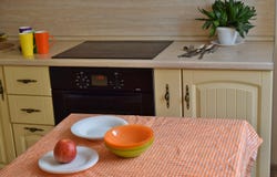 Sistema multicolor de platos de las placas, de las tazas, de las bifurcaciones, de las cucharas y de los cuchillos en la cocina e fotos de archivo libres de regalías Sistema multicolor de platos de las placas, de las tazas, de las bifurcaciones, de las cucharas y de los cuchillos en la cocina e fotos de archivo libres de regalías