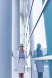 Situaci?n subrayada de la mujer de negocios al lado de la pared de un edificio de oficinas imagenes de archivo Situaci?n subrayada de la mujer de negocios al lado de la pared de un edificio de oficinas imagenes de archivo