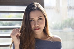 Situación hermosa de la mujer en una ventana de madera foto de archivo Situación hermosa de la mujer en una ventana de madera foto de archivo