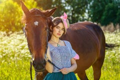 Situación hermosa de la mujer joven al lado de un caballo en naturaleza imagen de archivo libre de regalías Situación hermosa de la mujer joven al lado de un caballo en naturaleza imagen de archivo libre de regalías