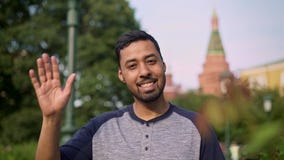 Situación sonriente y que agita turística hispánica de la mano cerca del Kremlin almacen de metraje de vídeo Situación sonriente y que agita turística hispánica de la mano cerca del Kremlin almacen de metraje de vídeo