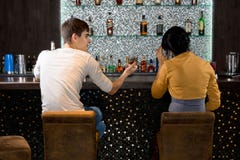 Sitzendes Trinken der jungen Paare an der Bar lizenzfreies stockfoto Sitzendes Trinken der jungen Paare an der Bar lizenzfreies stockfoto