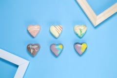 Six Belgian chocolate hearts with frames on blue background Stock Photo Six Belgian chocolate hearts with frames on blue background Stock Photo