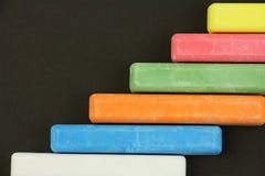 Six Colored Children Crayons On Black Background, On Right Side, Blue Red Green Yellow Orange White, Top View Royalty Free Stock Photography