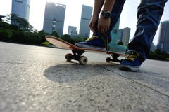 Skateboarder bindende schoenveter bij vleetpark royalty-vrije stock afbeelding Skateboarder bindende schoenveter bij vleetpark royalty-vrije stock afbeelding