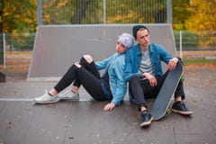 Skateres novos do indivíduo e da menina, fora em um dia brilhante do outono fotos de stock royalty free Skateres novos do indivíduo e da menina, fora em um dia brilhante do outono fotos de stock royalty free