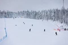 Skiers and snowboarders on a snowy slope in a ski resort in Finland.