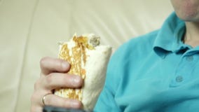 Skinny man eating junk food with great enjoyment. guy eats fast food snack. slow motion stock footage Skinny man eating junk food with great enjoyment. guy eats fast food snack. slow motion stock footage