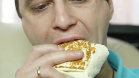 Skinny man eating junk food with great enjoyment. guy eats fast food snack. slow motion stock footage Skinny man eating junk food with great enjoyment. guy eats fast food snack. slow motion stock footage