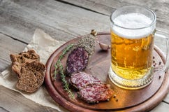 Skivor av den franska saucissonkorven med exponeringsglas av öl royaltyfria foton Skivor av den franska saucissonkorven med exponeringsglas av öl royaltyfria foton