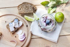 Skivor av den marinerade makrillen med löken i en krus, en limefrukt, ett lager och ett bröd fotografering för bildbyråer Skivor av den marinerade makrillen med löken i en krus, en limefrukt, ett lager och ett bröd fotografering för bildbyråer