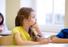 Skola flickan med pennan som borras i klassrum arkivfoton Skola flickan med pennan som borras i klassrum arkivfoton