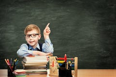 Skolbarn i klassrum över svart tavlabakgrund som pekar pojken arkivbild Skolbarn i klassrum över svart tavlabakgrund som pekar pojken arkivbild