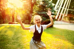 Skolflicka i likformig med glad dans för råttsvansar på solnedgång I fotografering för bildbyråer Skolflicka i likformig med glad dans för råttsvansar på solnedgång I fotografering för bildbyråer