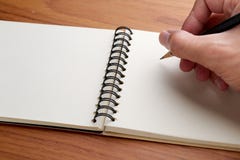 Skriva på anteckningsboken med blyertspennan Arkivbild Skriva på anteckningsboken med blyertspennan Arkivbild