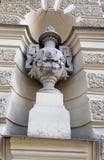 Skulptur av en vas med lejons huvud och prydnader på väggen av byggnaden royaltyfria bilder Skulptur av en vas med lejons huvud och prydnader på väggen av byggnaden royaltyfria bilder