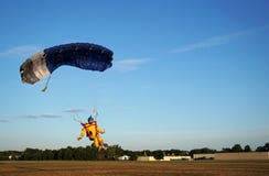 Skydiver под небольшой голубой сенью парашюта приземляется дальше стоковые фотографии rf Skydiver под небольшой голубой сенью парашюта приземляется дальше стоковые фотографии rf