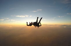 Skydivers que se divierten en la puesta del sol foto de archivo Skydivers que se divierten en la puesta del sol foto de archivo