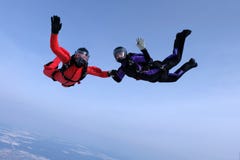 Skydiving in the blue sky.. Two skydivers send hello. stock photo Skydiving in the blue sky.. Two skydivers send hello. stock photo