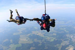 skydiving Il tandem e lo sportivo stanno afferrando le mani nel cielo immagine stock skydiving Il tandem e lo sportivo stanno afferrando le mani nel cielo immagine stock