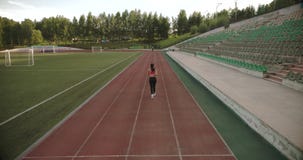 _ slank idrotts- flicka som joggar på stadion Attraktiv ung kvinna som utomhus övar lager videofilmer _ slank idrotts- flicka som joggar på stadion Attraktiv ung kvinna som utomhus övar lager videofilmer