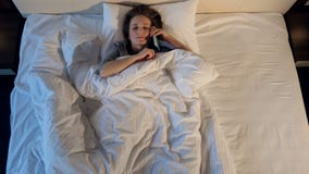 The sleeping girl answering the phone. Portrait. Close-up. 4K. stock video footage The sleeping girl answering the phone. Portrait. Close-up. 4K. stock video footage
