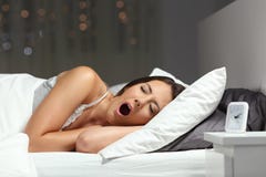 Sleepy woman yawning ready to sleep on a bed Stock Image Sleepy woman yawning ready to sleep on a bed Stock Image
