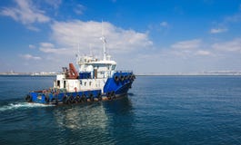 Slepend schip in de open zee, blauwe sleepboot die op overzees varen stock afbeeldingen Slepend schip in de open zee, blauwe sleepboot die op overzees varen stock afbeeldingen
