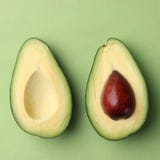 Sliced avocado on green background top view two half with seed royalty free stock photography Sliced avocado on green background top view two half with seed royalty free stock photography