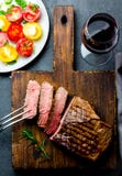 Sliced grillade medelsällsynt nötköttbiff som tjänades som på träbrädegrillfesten, fläskkarré för bbq-köttnötkött Den bästa sikte arkivfoto Sliced grillade medelsällsynt nötköttbiff som tjänades som på träbrädegrillfesten, fläskkarré för bbq-köttnötkött Den bästa sikte arkivfoto