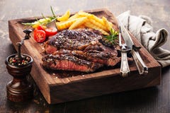 Sliced medium rare grilled Steak Ribeye with french fries stock photos Sliced medium rare grilled Steak Ribeye with french fries stock photos