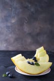 Sliced ripe melon on a plate on a dark stone background stock photography Sliced ripe melon on a plate on a dark stone background stock photography