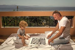 Slim peuterconcept Papa met het intellectuele spel van het kindspel Het schaak van het ouderspel met jong geitje op terras op zon royalty-vrije stock afbeelding Slim peuterconcept Papa met het intellectuele spel van het kindspel Het schaak van het ouderspel met jong geitje op terras op zon royalty-vrije stock afbeelding