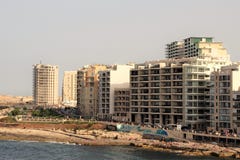 Slima, Malta, Lipiec 2014 Nowożytni budynki na nabrzeżu plaży i ludziach odpoczywać, obraz stock Slima, Malta, Lipiec 2014 Nowożytni budynki na nabrzeżu plaży i ludziach odpoczywać, obraz stock