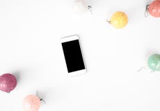 Slimme telefoon mobiele vertoning op de samenstellingsachtergrond van lijstkerstmis behang, decoratieballen, op witte achtergrond stock fotografie Slimme telefoon mobiele vertoning op de samenstellingsachtergrond van lijstkerstmis behang, decoratieballen, op witte achtergrond stock fotografie