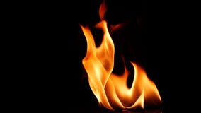 Slow motion closeup campfire burn on black background, fire flame design element