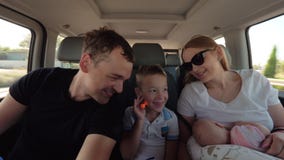 Happy parents with elder son and baby daughter having car journey stock video Happy parents with elder son and baby daughter having car journey stock video