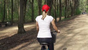 Slow Motion. Woman riding bike. Female teenager biking cycling in sunny park. Active sports concept stock video footage Slow Motion. Woman riding bike. Female teenager biking cycling in sunny park. Active sports concept stock video footage